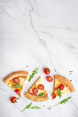 margherita pizza cut into slices on a white stone marble table
