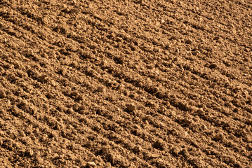Full-frame image of brown soil on a freshly ploughed field, suitable as an agricultural background texture