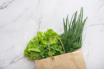 paper bag with greens on the table. food delivery. food shopping