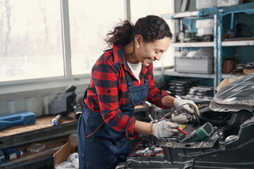 Delighted female mechanic working at service station