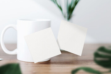 Clean minimal square flyer mockup floating on top table with cub and leaves