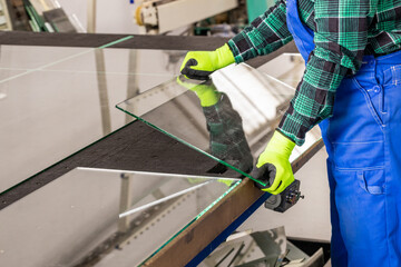 The glazier removes the cut glass from the specialized table in the glass factory, Cutting glass...