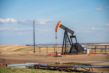Fototapeta na wymiar Pumpjacks working in the oil fields of Alberta on a spring day.