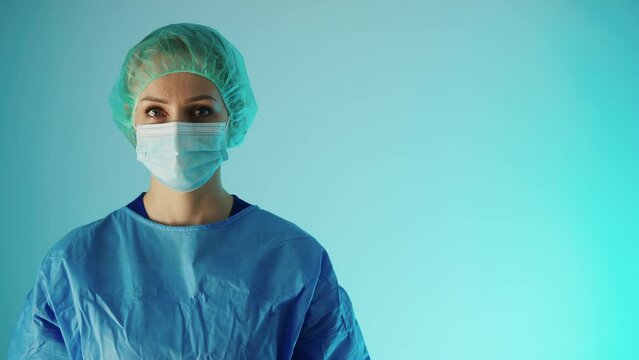 medium closeup shot of a female doctor in protection suit on blue background copy space medical concept. High quality 4k footage