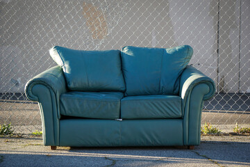 Couch behind fence outdoors in urban area