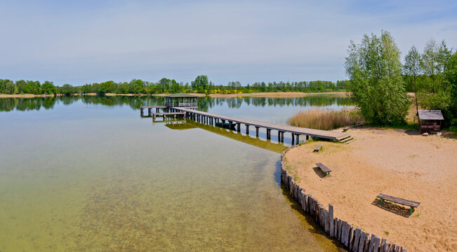 View of the lake shore with gangway and the bower at sunny day in Karsko, Poland