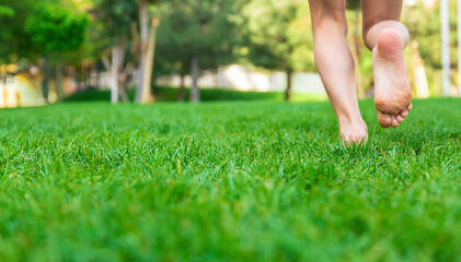Children's feet go on the grass. Selective focus.