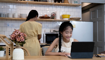 Homeschool Asian little young girl student learning virtual internet online class from school...