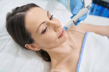 Woman having hydrafacial skincare procedure in beauty salon
