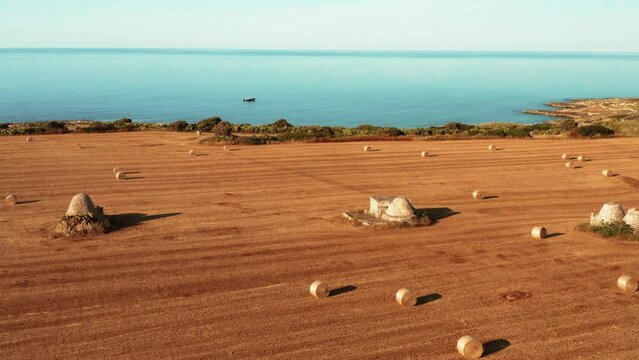 Costa dei trulli ripagnola in estate con le balle di fieno - Polignano a Mare, Bari, Puglia - vista dal drone 4K