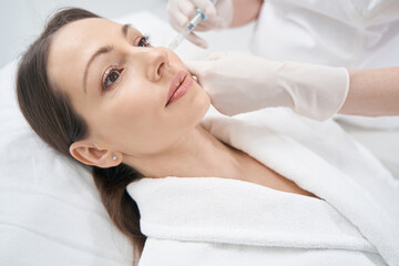 Obraz na płótnie Canvas Doctor beautician making contour plastic injection into woman face