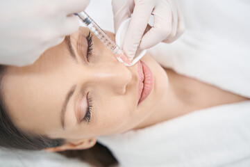 Obraz na płótnie Canvas Doctor beautician doing beauty injection in woman lips