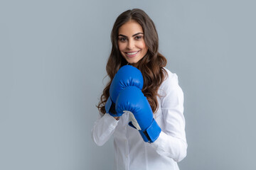 Attractive business woman with boxing gloves ready for a fight.