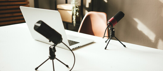 Podcast studio interior.  Two microphones on the table, close-up
