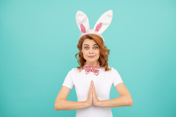 happy easter woman with rabbit ears on blue background. praying