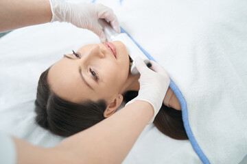Obraz na płótnie Canvas device under female chin during beauty therapy
