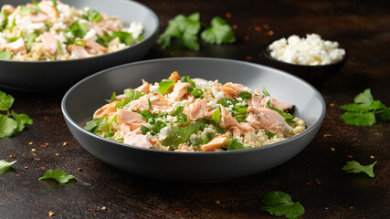 Salmon Couscous salad with feta cheese dressing and herbs. healthy food.