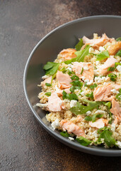 Salmon Couscous salad with feta cheese dressing and herbs. healthy food.