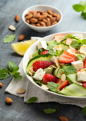 Summer Strawberry, cucumber salad with lettuce, feta cheese and almonds. Healthy Food.