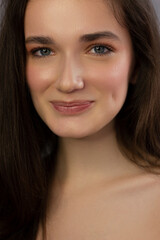 Obraz premium Close-up portrait of a beauty woman with full lips, straight hair and perfectly clean skin. Daytime makeup, styling and soft care. Skin care in the spa salon or cosmetology, smooth eyebrows