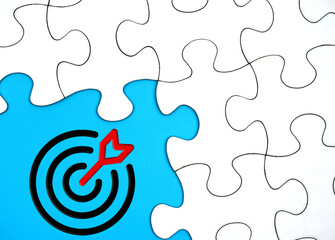 target icon on blue background surrounded by puzzle pieces. Business target concept. 