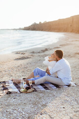 Happy romantic middle aged couple on the beach. Picnic by the sea.