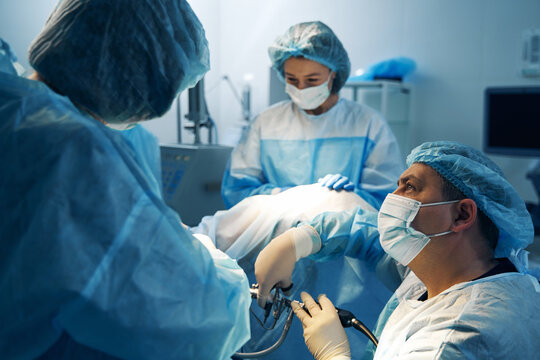 Surgeon Looking At Nurse While Doing Laparoscopic Surgery