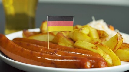 Close up of plate with tasty sausages and flag of Germany. German national food. Glass of beer on the background. - Powered by Adobe