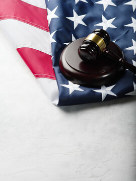 State american flag and wooden gavel of a judge on a white background. Symbols of legality, justice, rule of law. There are no people in the photo. There is free space to insert.