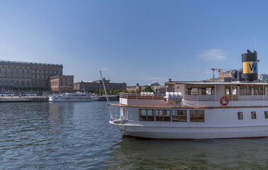 Bay view with commuting boats at the old town Gamla Stan, cultural buildings and castle a sunny day in Stockholm
