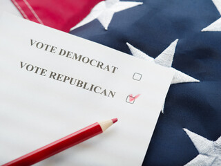 A checkmark opposite the Republican Party on the ballot, a red pencil against the background of the national American flag. Election campaign, election campaign, debates, rallies. - Powered by Adobe