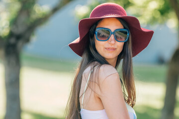 girl portrait in summer with sunglasses and hat