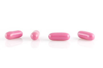 Obraz na płótnie Canvas Pink capsules with medical drugs or supplements isolated on white background. Close-up