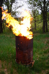 Flames spreading out from a fire 
 metal barrel 