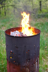 Flames spreading out from a fire 
 metal barrel 