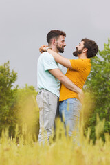 Young gay male couple, embracing in the park. High quality photo