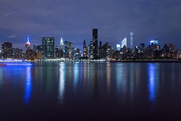 Obraz premium New York City Manhattan midtown panorama at dusk with skyscrapers illuminated over east river