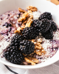 Blueberry, coconut, walnut oatmeal healthy breakfast in a bowl on a table