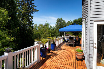 Home wood deck with patio furniture and plants for the summer season - 506292057