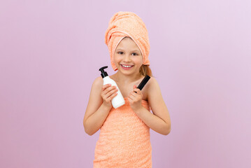 A little girl is going to spread cream on her body after a shower. children's body hygiene, a joyful child with a towel on his head.