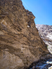 a river flowing along the rocks with blue sky