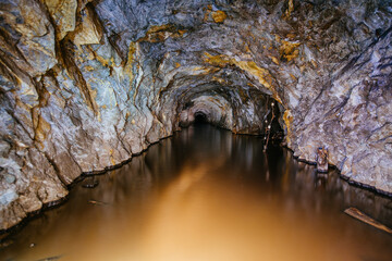 Dark flooded abandoned mine tunnel