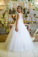 Fototapeta premium young caucasian brazilian bride at her wedding with decorated background, makeup and hairstyle.