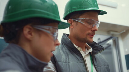 Facility supervisors inspecting manufacture closeup. Managers working together.