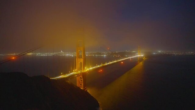 Time lapse San Francisco Golden Gate Bridge with glowing lights and fog. California, USA