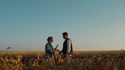 Two farmers meeting wheat field sunlight. Successful agriculture business deal.