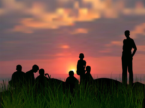 family silhouettes in grass at sunset