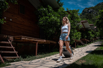 young woman entering the resort town with her suitcase