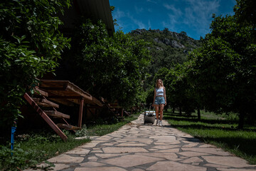 young woman entering the resort town with her suitcase