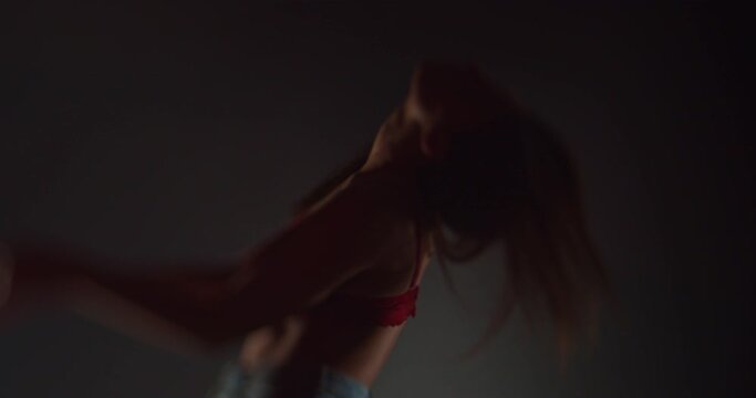 Beautiful girl dancing in bra and jeans, selective focus, silhouette